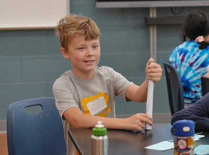  Student holds item during summer reading program